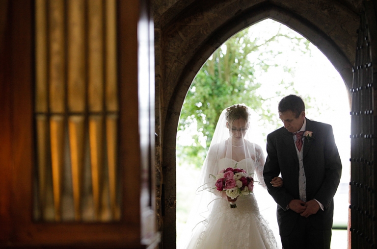 the bride arriving for the wedding ceremony at Fawsley Church in Northamptonshire