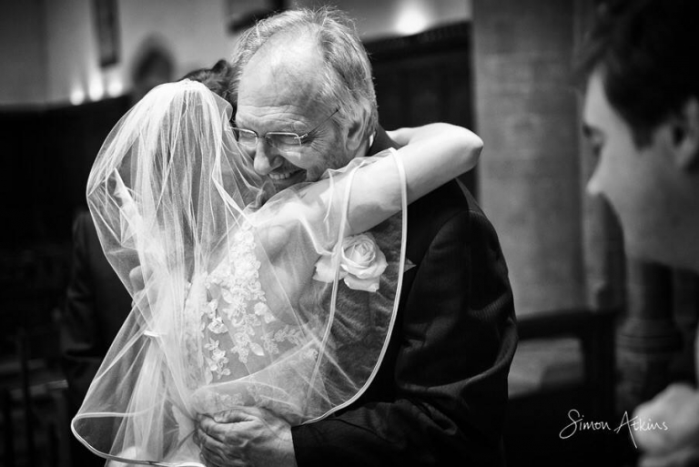 a father hugs his daughter after her wedding