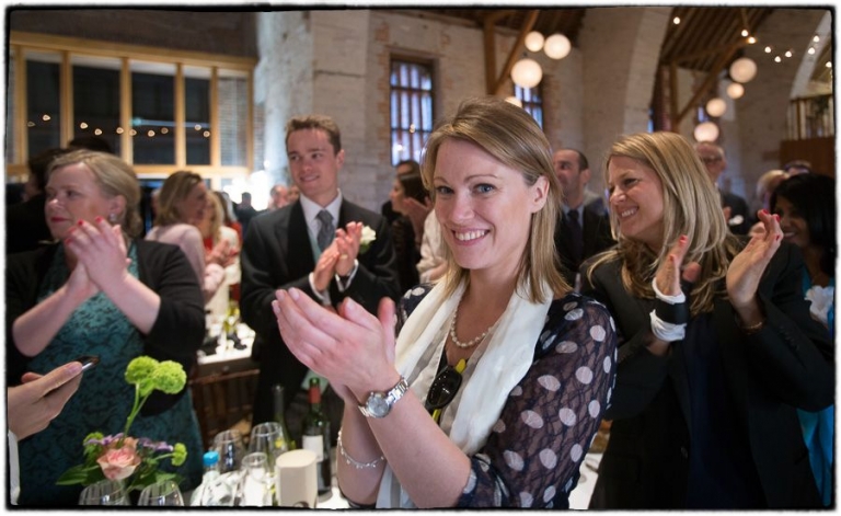 guests clap as the couple arrive for the wedding breakfast at a tithe barn wedding