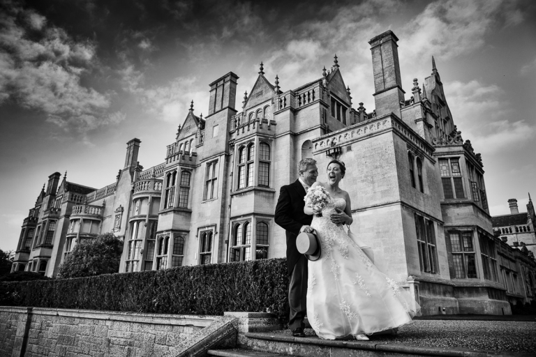 Joanna and Roger in front of Rushton Hall after their wedding ceremony