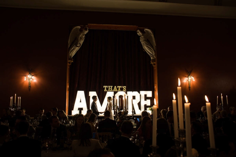 Hampton Court House wedding couple in front of illuminated sign