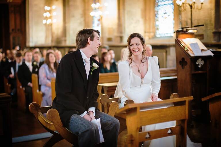 The bride and groom smiling at each other during a wedding ceremony at St Etheldreda's church 