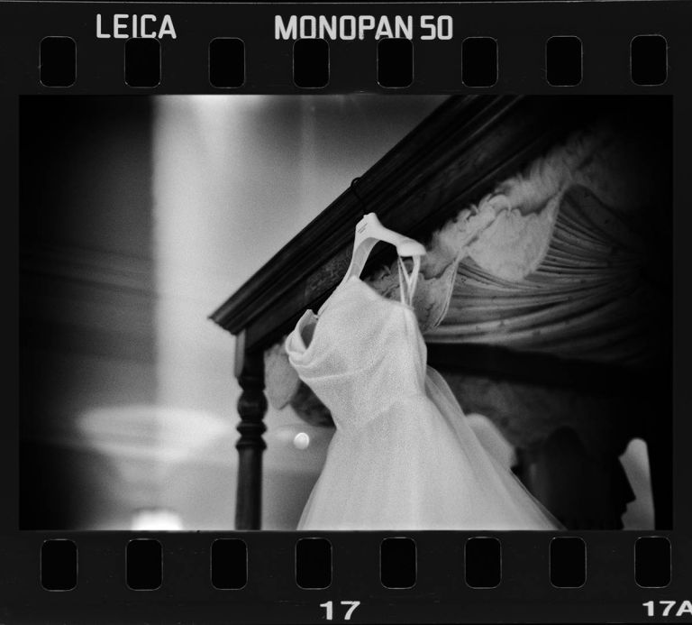 The bride's wedding dress hanging up, shot on Leica Monopan 50 film using a Leica M4-P and 50mm F1 lens.